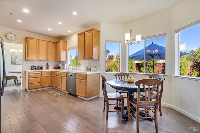 kitchen with pendant lighting, dark hardwood / wood-style floors, decorative backsplash, stainless steel dishwasher, and a chandelier