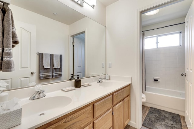 full bathroom with vanity, tiled shower / bath, and toilet