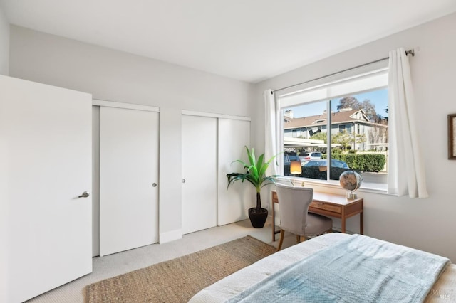 carpeted bedroom featuring multiple closets