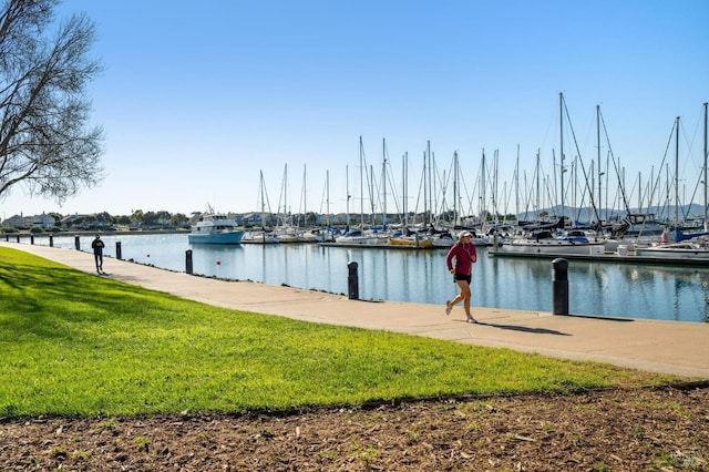 dock area featuring a water view and a lawn