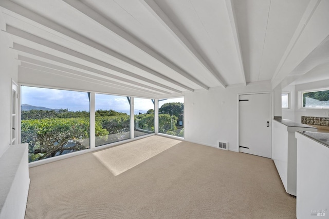 interior space featuring beamed ceiling and carpet