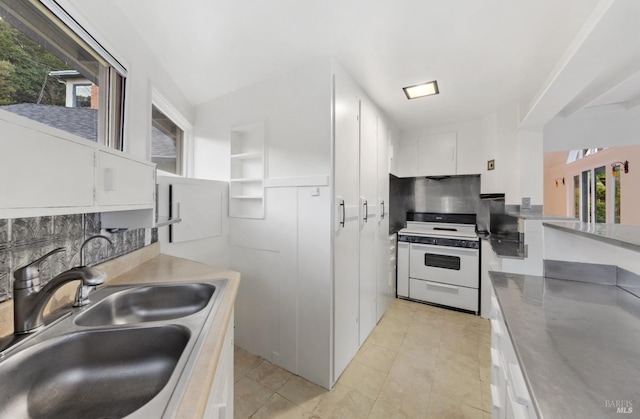 kitchen with white range with electric stovetop, sink, decorative backsplash, and white cabinets