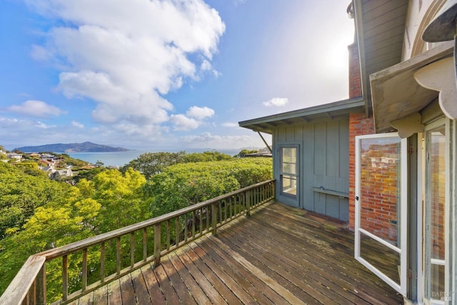 wooden terrace with a water and mountain view