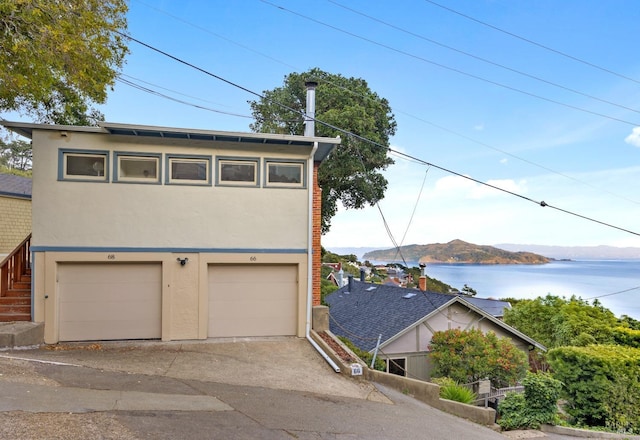 exterior space featuring a garage and a water and mountain view