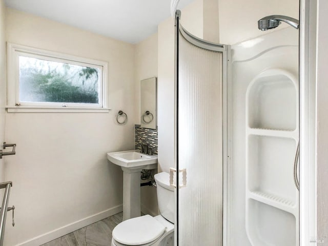 bathroom featuring walk in shower, toilet, and backsplash