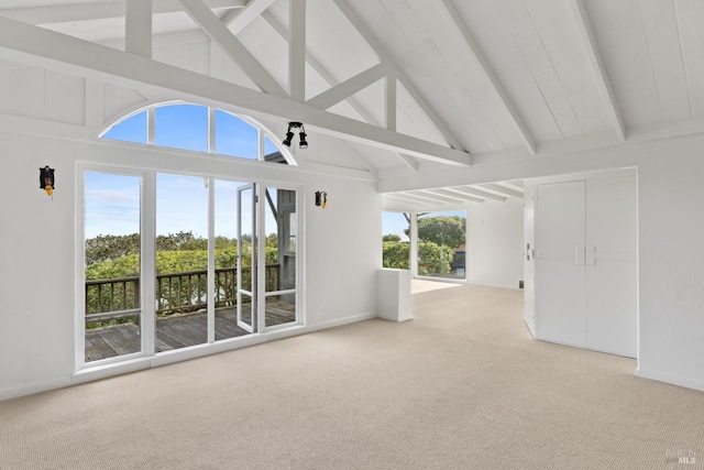 unfurnished living room with beamed ceiling, carpet floors, and high vaulted ceiling