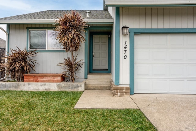 entrance to property with a garage and a lawn