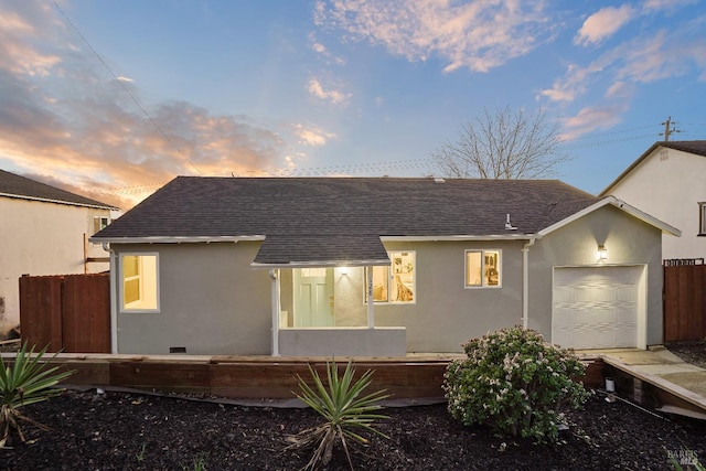 back house at dusk featuring a garage