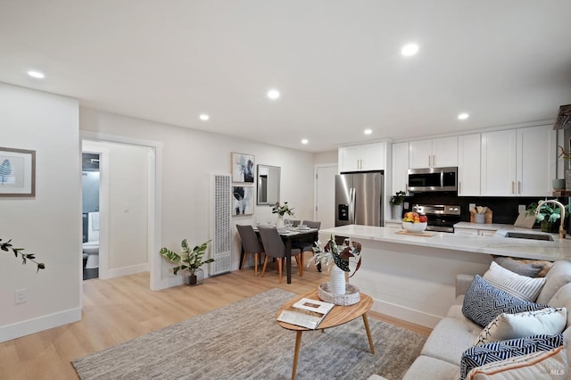 living room featuring sink and light hardwood / wood-style flooring