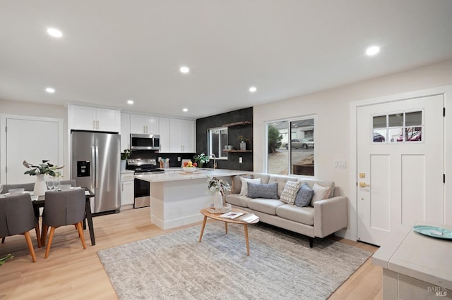 living room with sink and light hardwood / wood-style floors