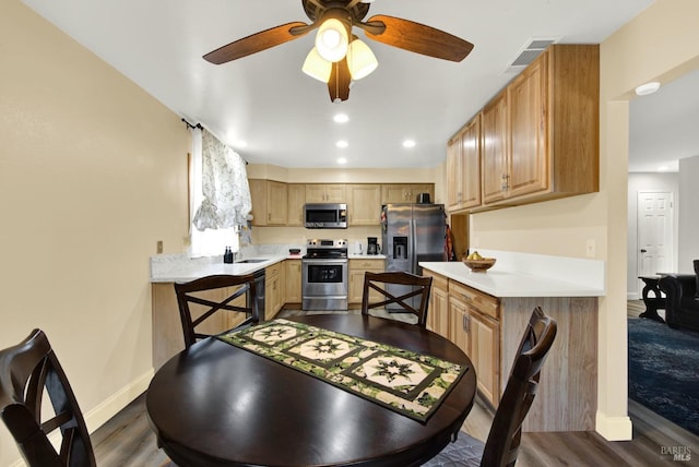 kitchen featuring sink, appliances with stainless steel finishes, dark hardwood / wood-style floors, kitchen peninsula, and light brown cabinets