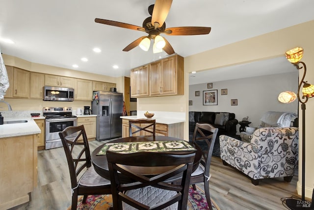 dining space featuring sink, light hardwood / wood-style flooring, and ceiling fan