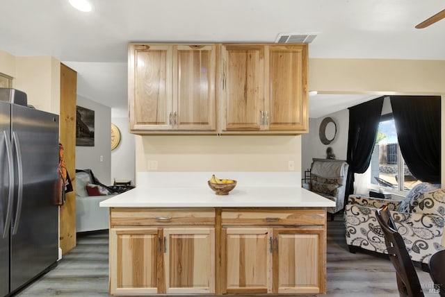 kitchen with dark wood-type flooring, stainless steel fridge, and light brown cabinetry