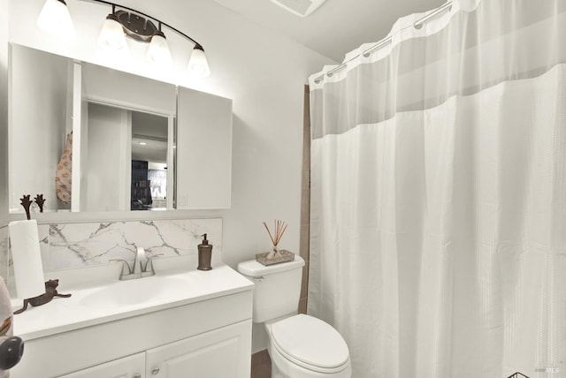 bathroom featuring vanity, decorative backsplash, and toilet