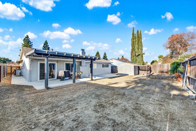 rear view of house featuring a storage unit and a patio