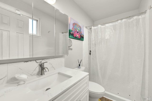 bathroom featuring tasteful backsplash, vanity, a shower with shower curtain, and toilet