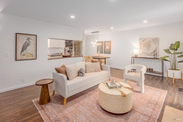 living room featuring wood-type flooring and a chandelier