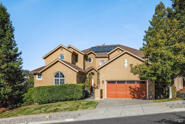 view of front facade featuring a garage and solar panels