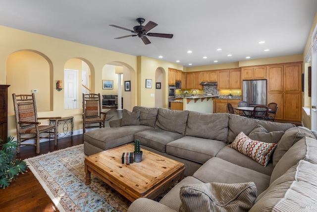 living room with ceiling fan and dark hardwood / wood-style flooring