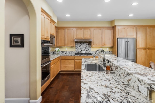 kitchen with sink, light brown cabinets, dark hardwood / wood-style floors, stainless steel appliances, and light stone countertops