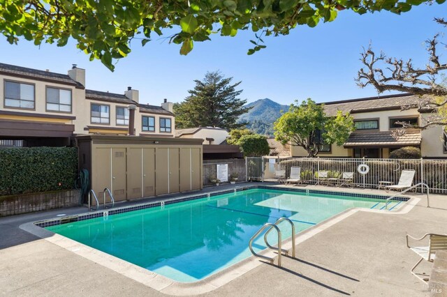 community pool with a patio area and fence