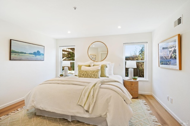 bedroom featuring multiple windows and light hardwood / wood-style floors