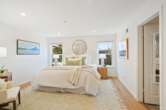 bedroom featuring multiple windows and light hardwood / wood-style flooring