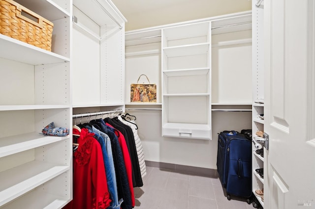 walk in closet with light tile patterned floors