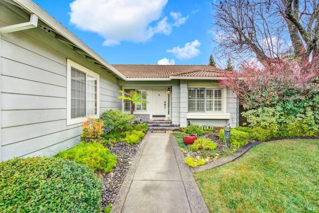 property entrance featuring a lawn