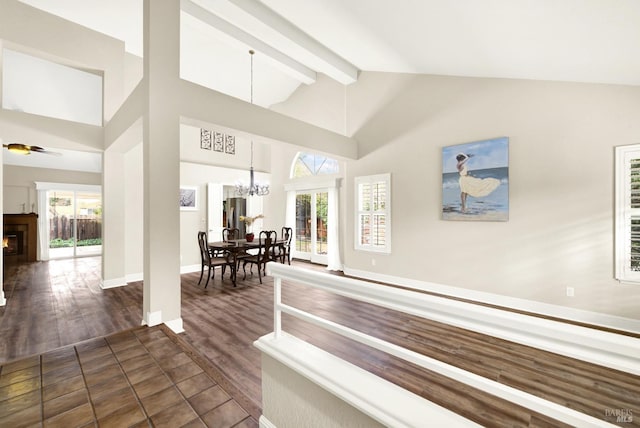 interior space with beamed ceiling, high vaulted ceiling, plenty of natural light, and an inviting chandelier