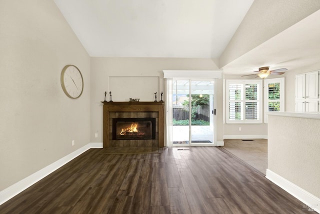 unfurnished living room with lofted ceiling, hardwood / wood-style flooring, ceiling fan, and a tiled fireplace