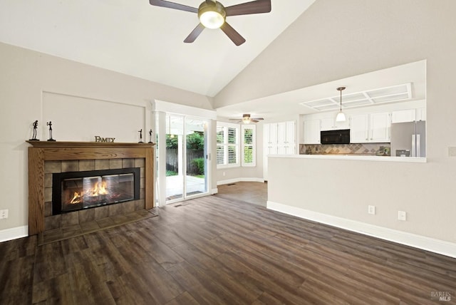 unfurnished living room featuring dark hardwood / wood-style flooring, high vaulted ceiling, ceiling fan, and a fireplace