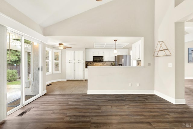 kitchen featuring white cabinetry, decorative light fixtures, stainless steel fridge, kitchen peninsula, and decorative backsplash