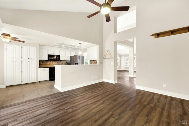 kitchen featuring decorative light fixtures, tasteful backsplash, white cabinetry, kitchen peninsula, and stainless steel refrigerator with ice dispenser