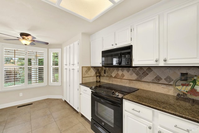 kitchen with light tile patterned floors, white cabinetry, dark stone countertops, tasteful backsplash, and black appliances