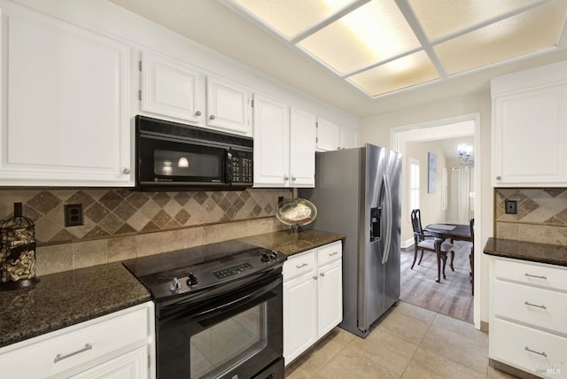 kitchen featuring black appliances, white cabinets, light tile patterned flooring, decorative backsplash, and dark stone counters