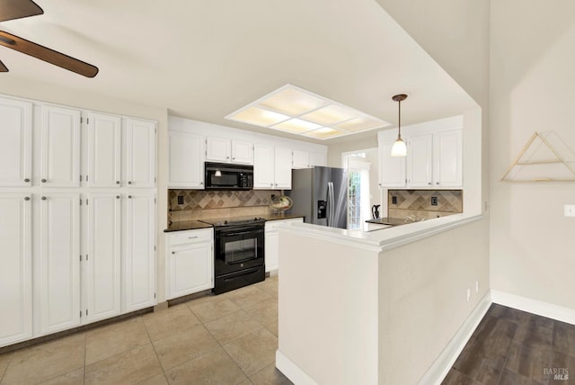 kitchen with white cabinetry, tasteful backsplash, kitchen peninsula, pendant lighting, and black appliances