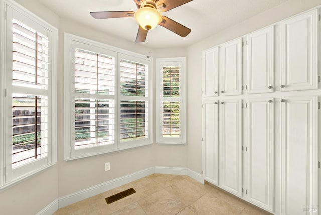 interior space featuring light tile patterned flooring, plenty of natural light, and ceiling fan