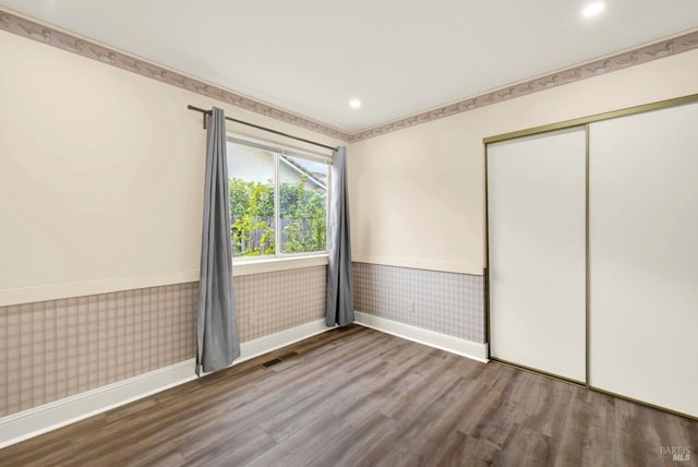 unfurnished bedroom with wood-type flooring and a closet