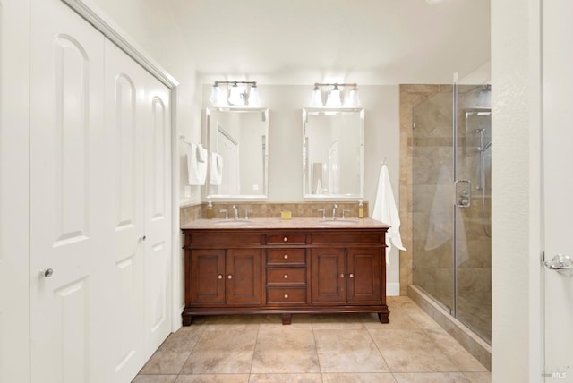 bathroom featuring vanity, an enclosed shower, tile patterned flooring, and backsplash