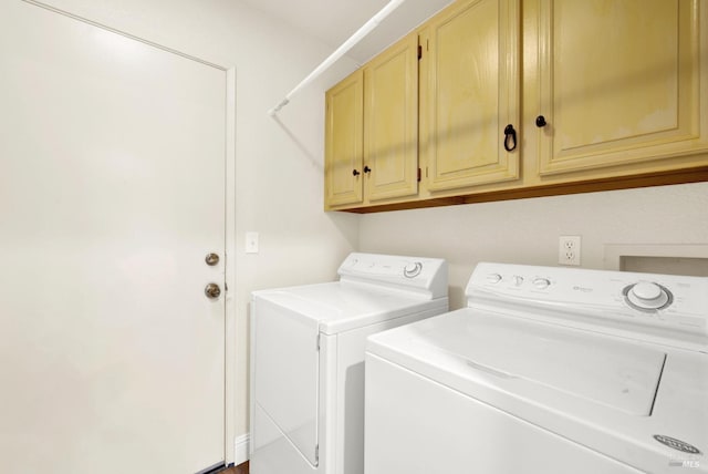 clothes washing area with cabinets and washer and dryer