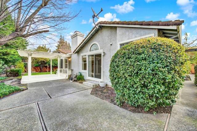 view of home's exterior with a pergola and a patio