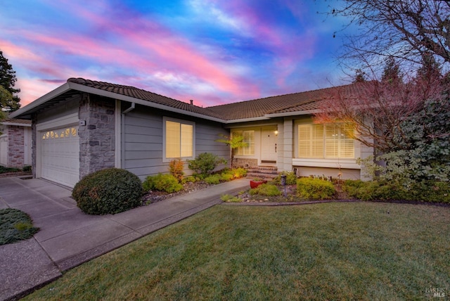 single story home with a garage and a yard