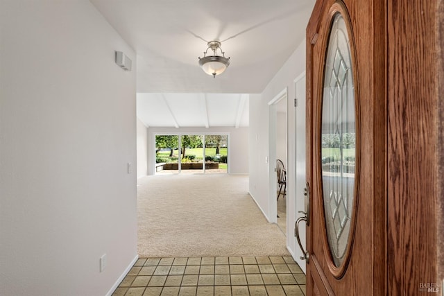 hallway with vaulted ceiling and carpet