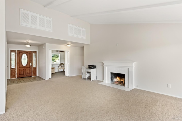 unfurnished living room featuring beamed ceiling, a brick fireplace, high vaulted ceiling, and light carpet