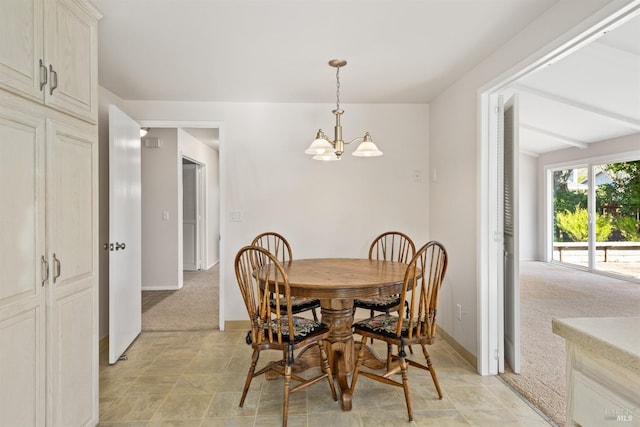 carpeted dining space with a chandelier