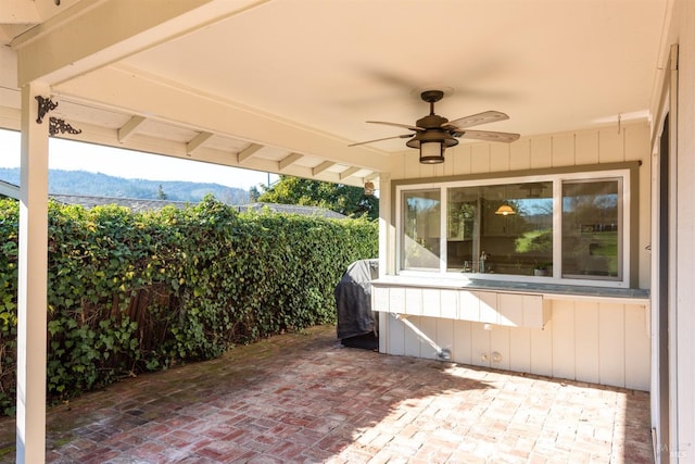 view of patio / terrace featuring a mountain view, a grill, and ceiling fan