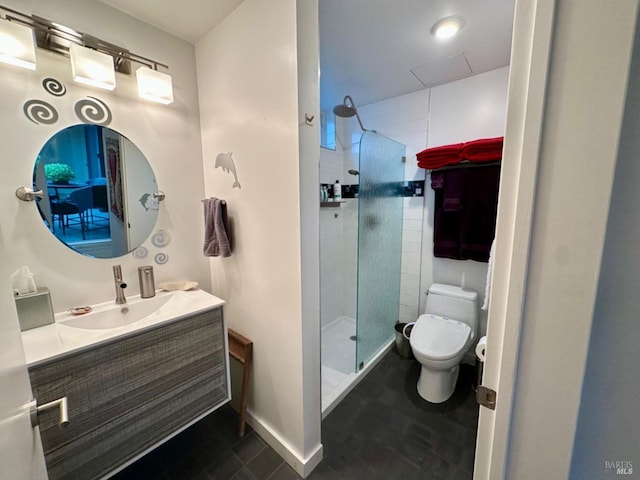 bathroom with vanity, a tile shower, and toilet