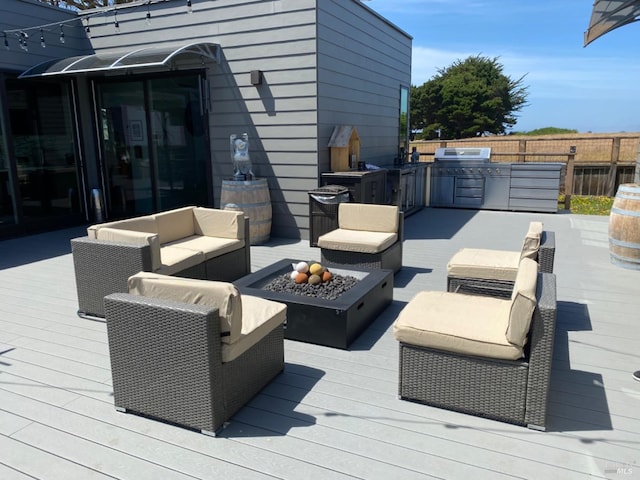 wooden deck featuring area for grilling, an outdoor hangout area, and exterior kitchen