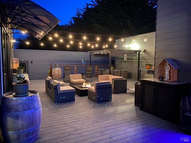 deck at twilight with a pergola and an outdoor living space with a fire pit